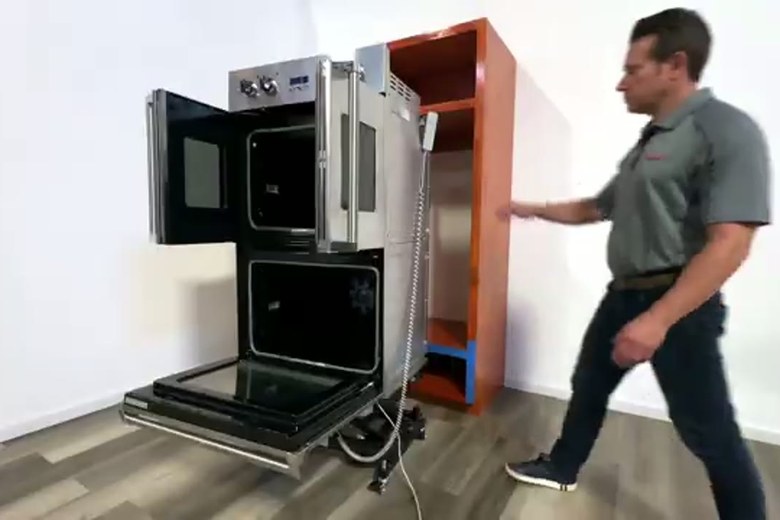 Easing a heavy cabinet onto the dolly